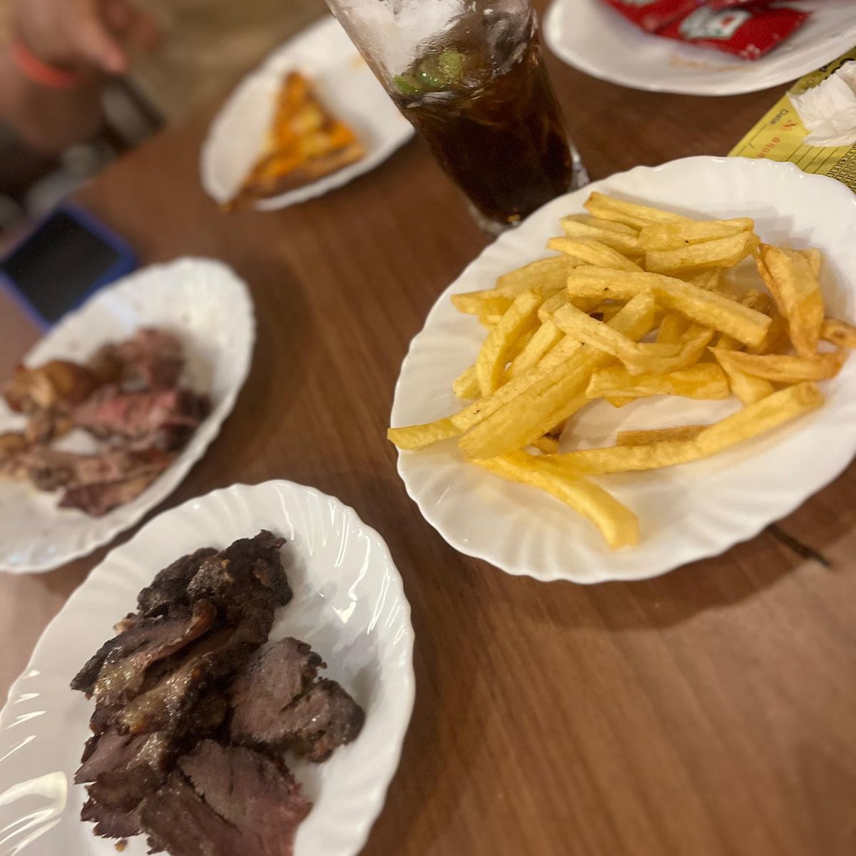Porção de carne com fritas na mesa
